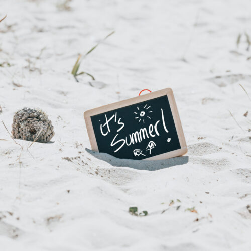 black-chalkboard-in-the-sand-reads-its-summer